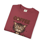 A folded maroon t-shirt featuring a cartoon kitten graphic and the word COFFEE.
