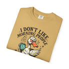 Tan t-shirt featuring a graphic of a grumpy duck holding a coffee mug with the text I DON'T LIKE.