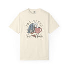 Cream-colored unisex t-shirt with a distressed graphic of a duck with its head in a coffee mug.