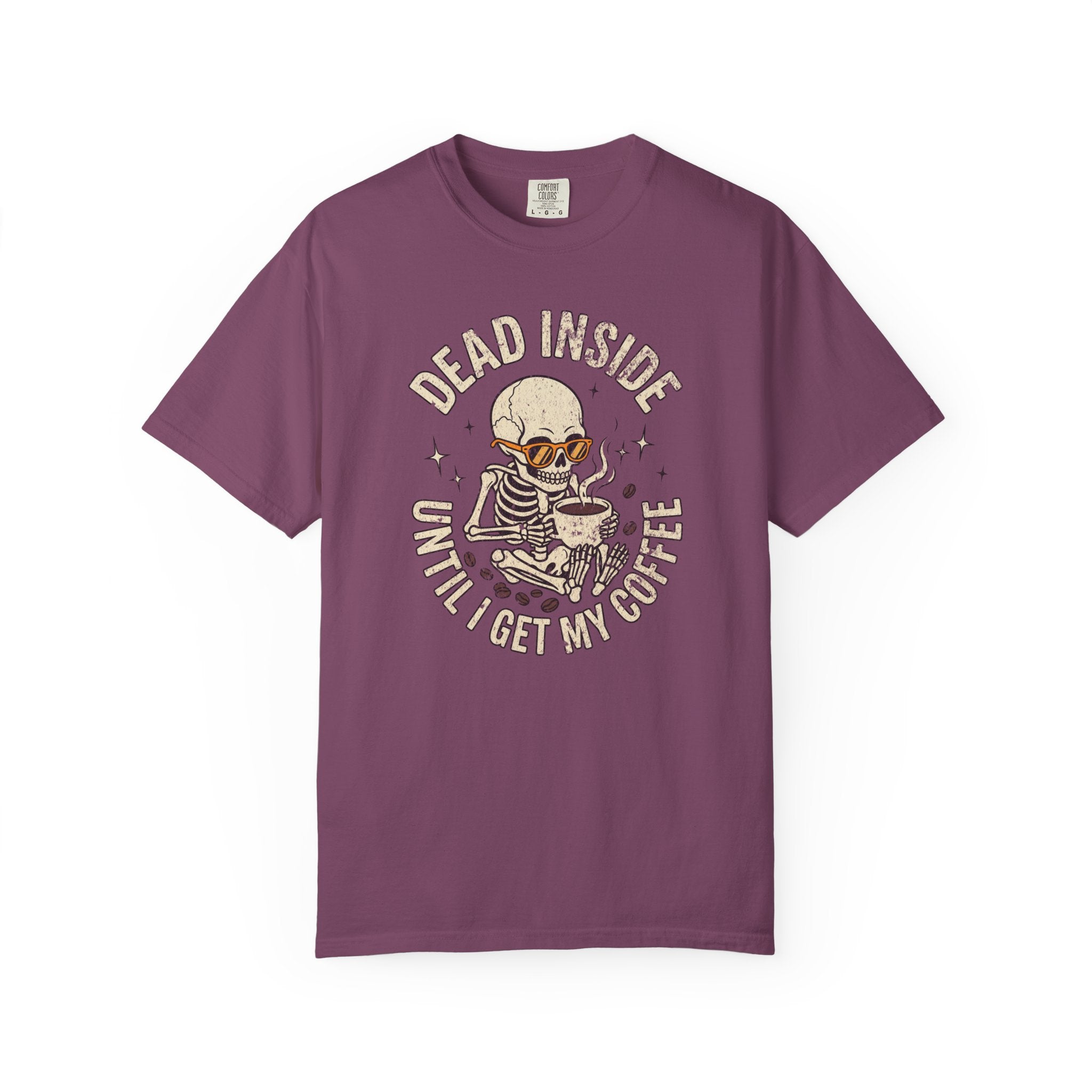 Purple t-shirt with a distressed graphic of a skeleton wearing sunglasses and holding coffee.
