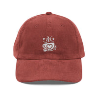 Red corduroy baseball cap with an embroidered white coffee cup and heart logo on the front.