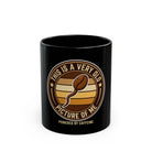 Black ceramic coffee mug featuring a coffee bean shaped like a sperm with text about caffeine.