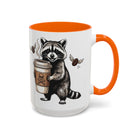 White ceramic mug with an orange handle and interior, featuring a raccoon holding a coffee cup.