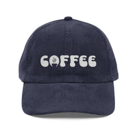 A navy blue corduroy dad hat featuring the word coffee embroidered in white on the front.