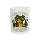 White mug featuring a cartoon frog making peace signs with the text Caution Without Coffee No Filter