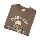 Brown t-shirt with a distressed graphic of a skeleton wearing orange sunglasses drinking coffee.