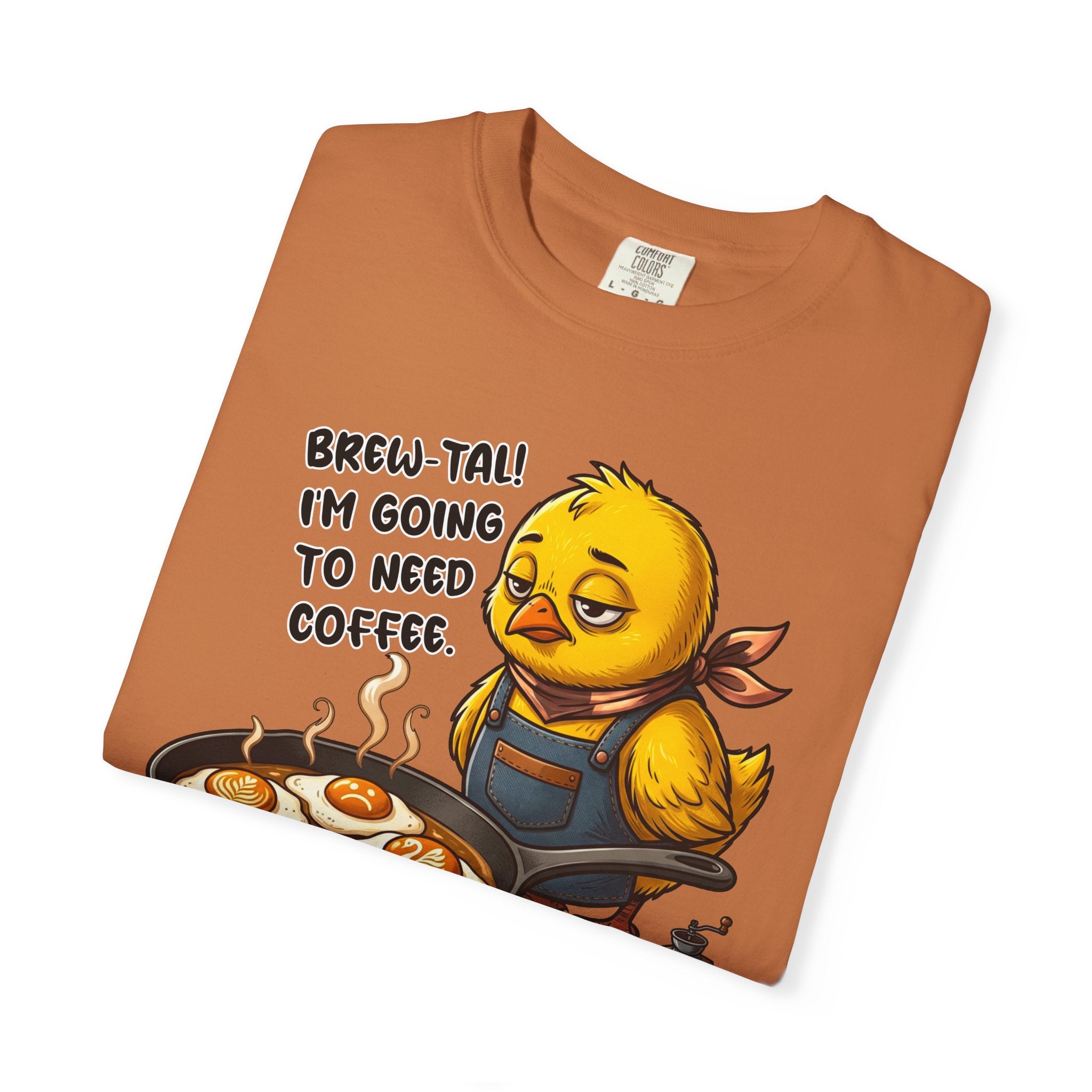 Orange Comfort Colors t-shirt featuring a sleepy chick in an apron cooking eggs in a pan.