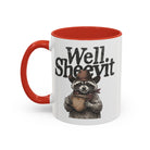 White ceramic mug with a red handle and rim, featuring a raccoon in a cowboy hat holding a mug.