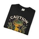 Black t-shirt featuring a graphic of a frog making peace signs with the word CAUTION above it.