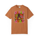 A rust-colored t-shirt featuring a retro, psychedelic graphic that says Decaf Is A Joke.