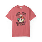 A coral-colored t-shirt featuring a grumpy duck holding a coffee mug with the text above and below.
