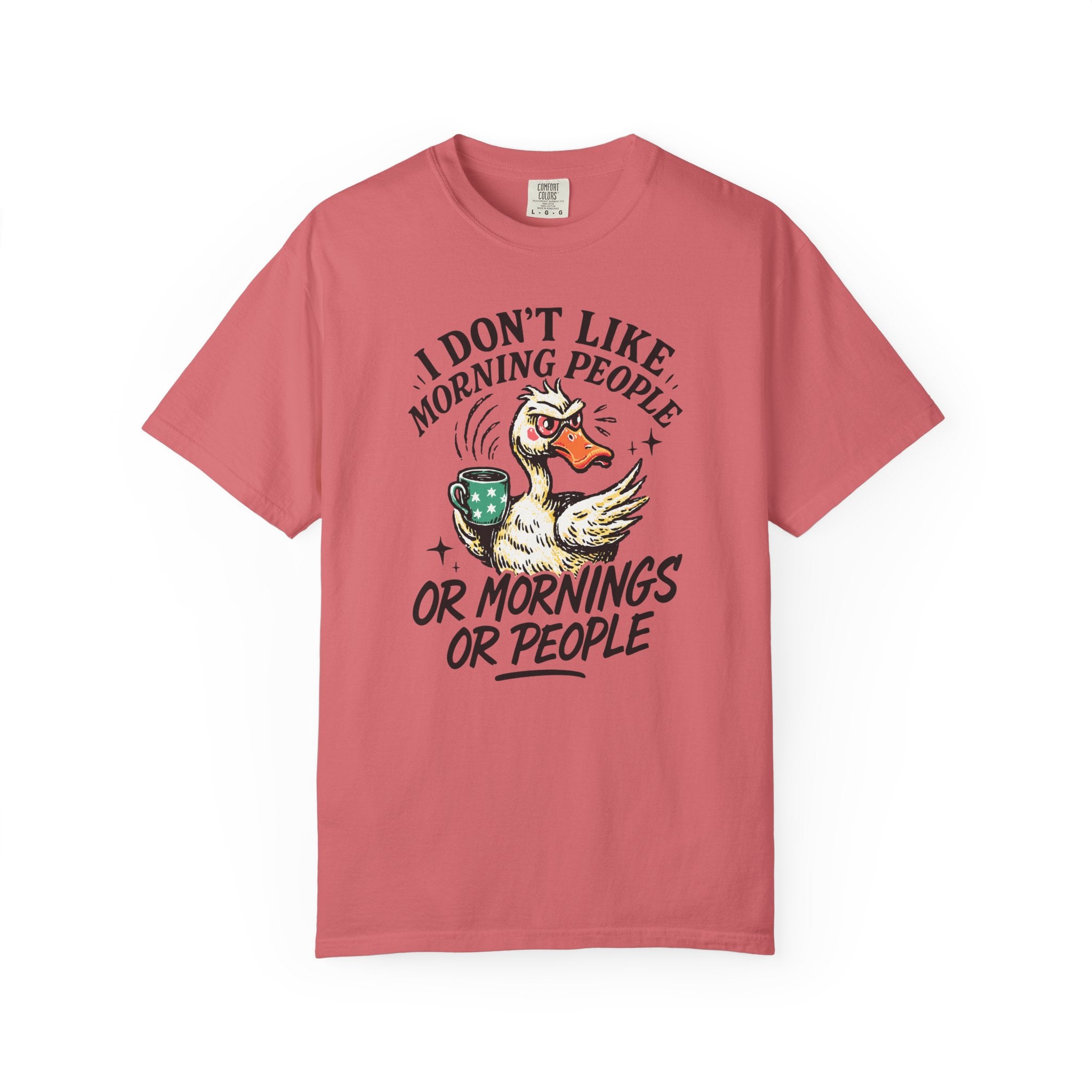 A coral-colored t-shirt featuring a grumpy duck holding a coffee mug with the text above and below.
