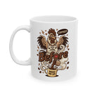 White ceramic mug featuring a cartoon rooster wearing an apron with the text Rise and Shine.