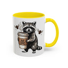 White ceramic mug with a yellow handle and interior, featuring a raccoon holding a coffee cup.