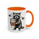 White ceramic mug with an orange interior and handle, featuring a raccoon holding a coffee cup.