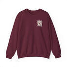 A maroon crewneck sweatshirt featuring the text Drip With Sarcasm in white on the left chest.