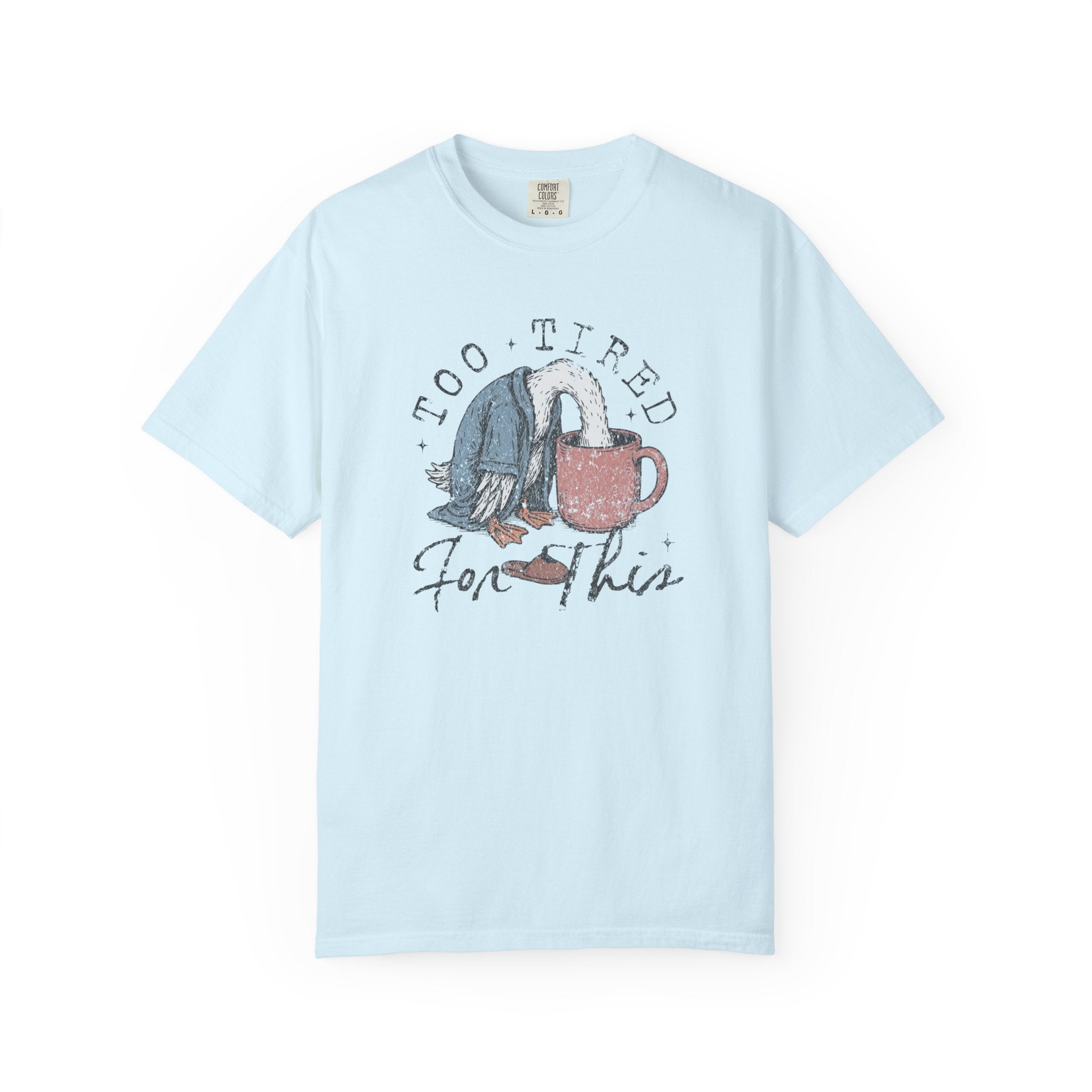 Light blue t-shirt with a graphic of a bird with its head in a coffee mug and text Too Tired For This