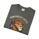 Folded grey t-shirt featuring a graphic of a lion wearing a red bandana with Powered by Coffee text.