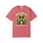 A coral-colored t-shirt featuring a green alien wearing sunglasses and making peace signs.