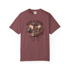 A maroon t-shirt featuring a graphic of a cowboy rooster pouring coffee into a mug.